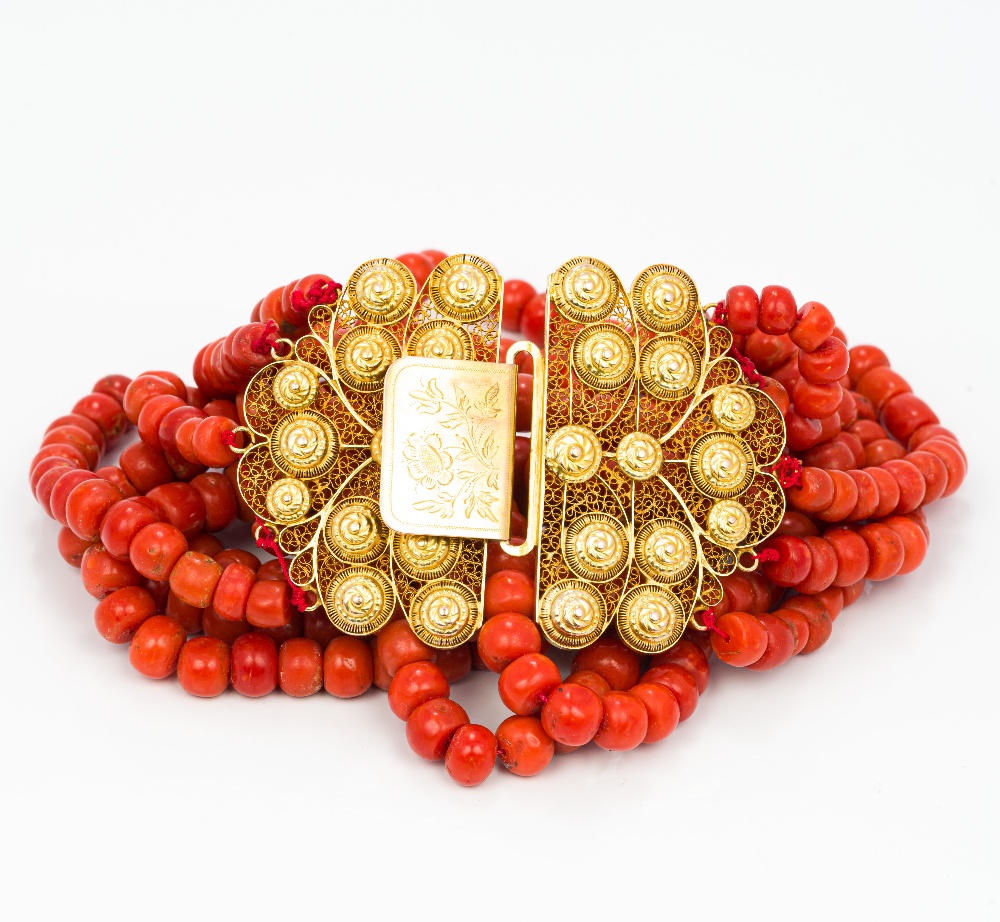 A six strand coral bead necklace Set with 18 ct gold filigree clasp. Approximately 38 cm long.