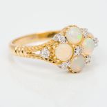A 9 ct gold diamond and opal set ring The four cabochon opals surrounded by seven small diamonds.