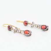 A pair of Art Deco unmarked 9 ct gold cabochon garnet and diamond earrings Each of pierced drop