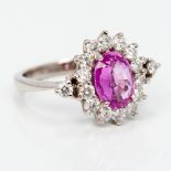 An 18 ct white gold diamond and pink sapphire ring The central facet cut claw set sapphire