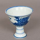 A small Chinese blue and white porcelain stem cup Decorated in the round with a phoenix chasing a