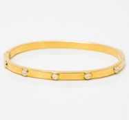 An 18 ct gold Cartier style bangle Of hinged form. 6.75 cm wide.