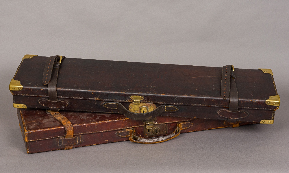 Two vintage leather gun cases One set with brass corners, each lid initialled.