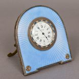 A Cartier guilloche enamel decorated silver strutt clock The white enamelled dial with Roman and