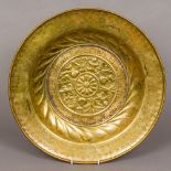 A 17th century Art brass alms dish With repousse and engraved decoration. 42.5 cm diameter.