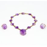 A 14K gold necklace Set with florally carved amethyst roundels centred with a florally carved