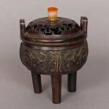 A Chinese patinated bronze censer Of squat bulbous form, with twin loop handles and elongated legs,
