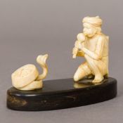 A late 19th century Indian carved ivory group Formed as a snake charmer and cobra,