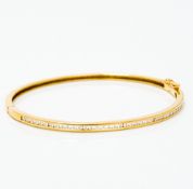 An 18 ct gold and diamond bangle Of hinged form, one side channel set with diamonds. 6.5 cm wide.