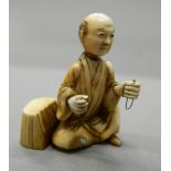 A 19th century ivory netsuke of a man seated beside a tree stump. 4.25 cm high.