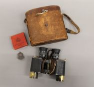 A pair of cased binoculars and an ARP badge. The case 15.5 cm high.