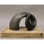 A ram's horn mounted on a wooden plinth. 27.5 cm wide.