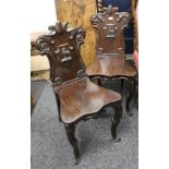 A pair of Victorian mahogany hall chairs, the backs each set with a carved ostrich. 92 cm high.