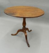 A 19th century oak and mahogany tripod table. 75 cm diameter.