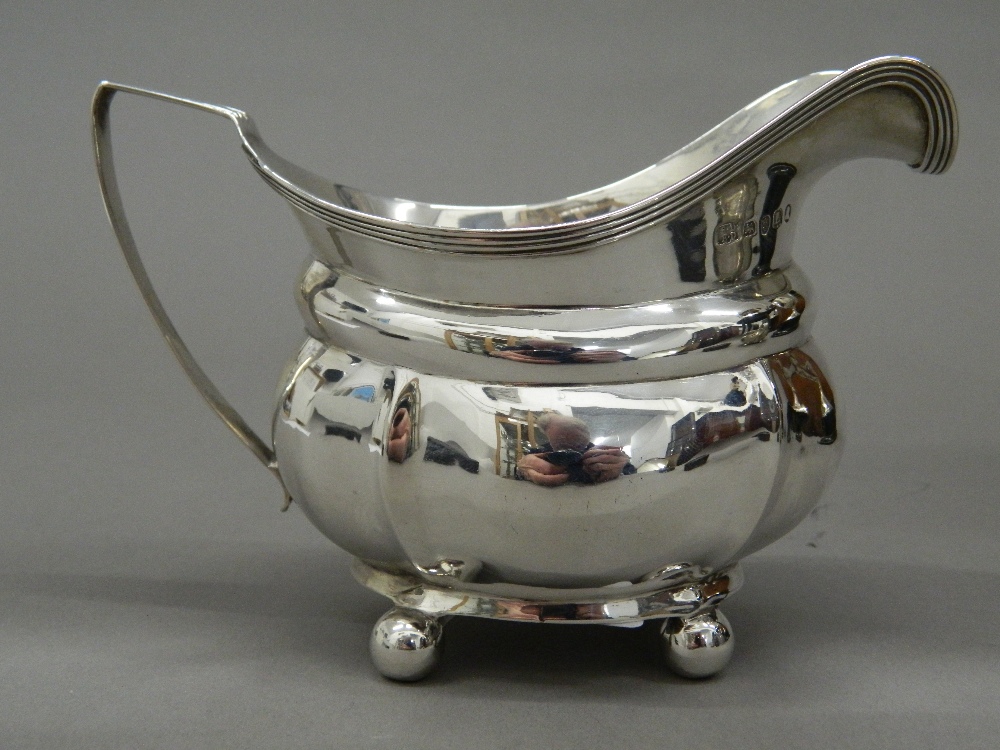 A silver cream jug. 14 cm wide (4.