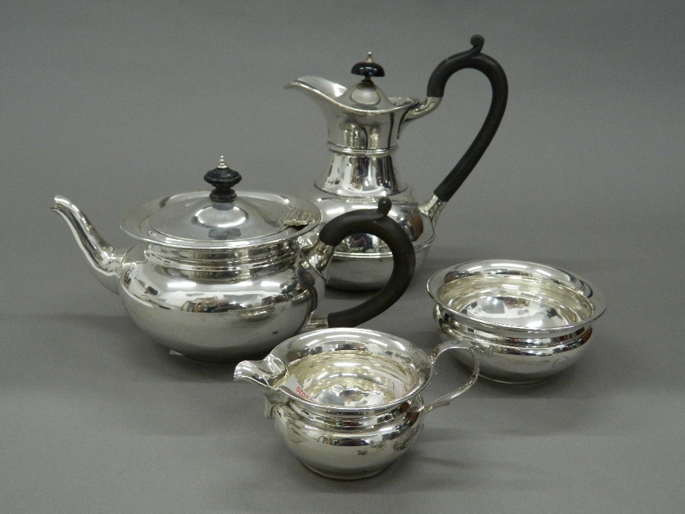 A silver four piece tea set. Coffee pot 18 cm high (25.