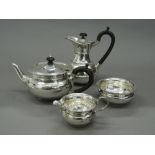 A silver four piece tea set. Coffee pot 18 cm high (25.