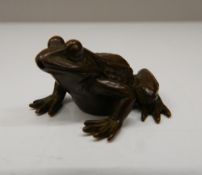 A Japanese bronze model of a frog. 2.25 cm high; 4 cm long.