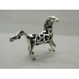 A silver pin cushion formed as a horse. 4 cm wide.