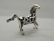 A silver pin cushion formed as a horse. 4 cm wide.