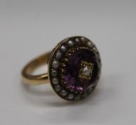 An unmarked gold, possibly 18 ct gold, pearl and amethyst elaborately worked circular form ring,