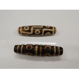 Two agate dzi beads. 6 cm and 5 cm long respectively.