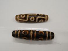 Two agate dzi beads. 6 cm and 5 cm long respectively.