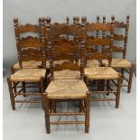 Eight ladder back rush seated chairs. 118 cm high.