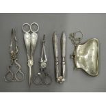 A quantity of plated tongs and a purse. Largest tongs 17.