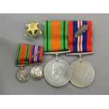 A pair of WWII medals with ribbons (1939-1945 Service Medal and The Defence Medal) and miniatures;
