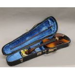A cased violin. 58.5 cm long.