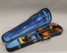 A cased violin. 58.5 cm long.