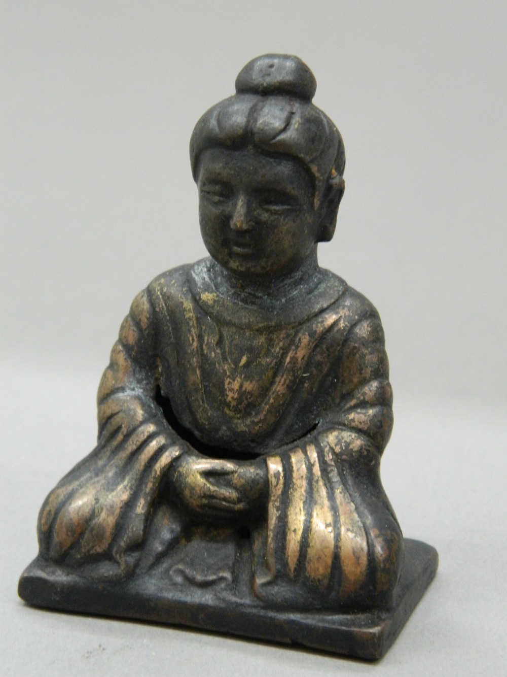 A small bronze seated Buddha. 7 cm high.