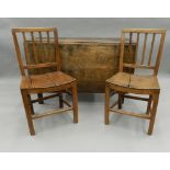 A 19th century oak drop leaf table and two 19th century solid seated chairs. The table 113 cm wide.