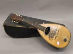 A cased mandolin. 61 cm long.