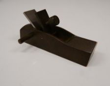 A bronze model of a wood plane. 9 cm long.