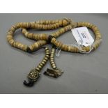 A small Tibetan necklace. Approximately 58 cm long, each disc approximately 0.75 cm diameter.