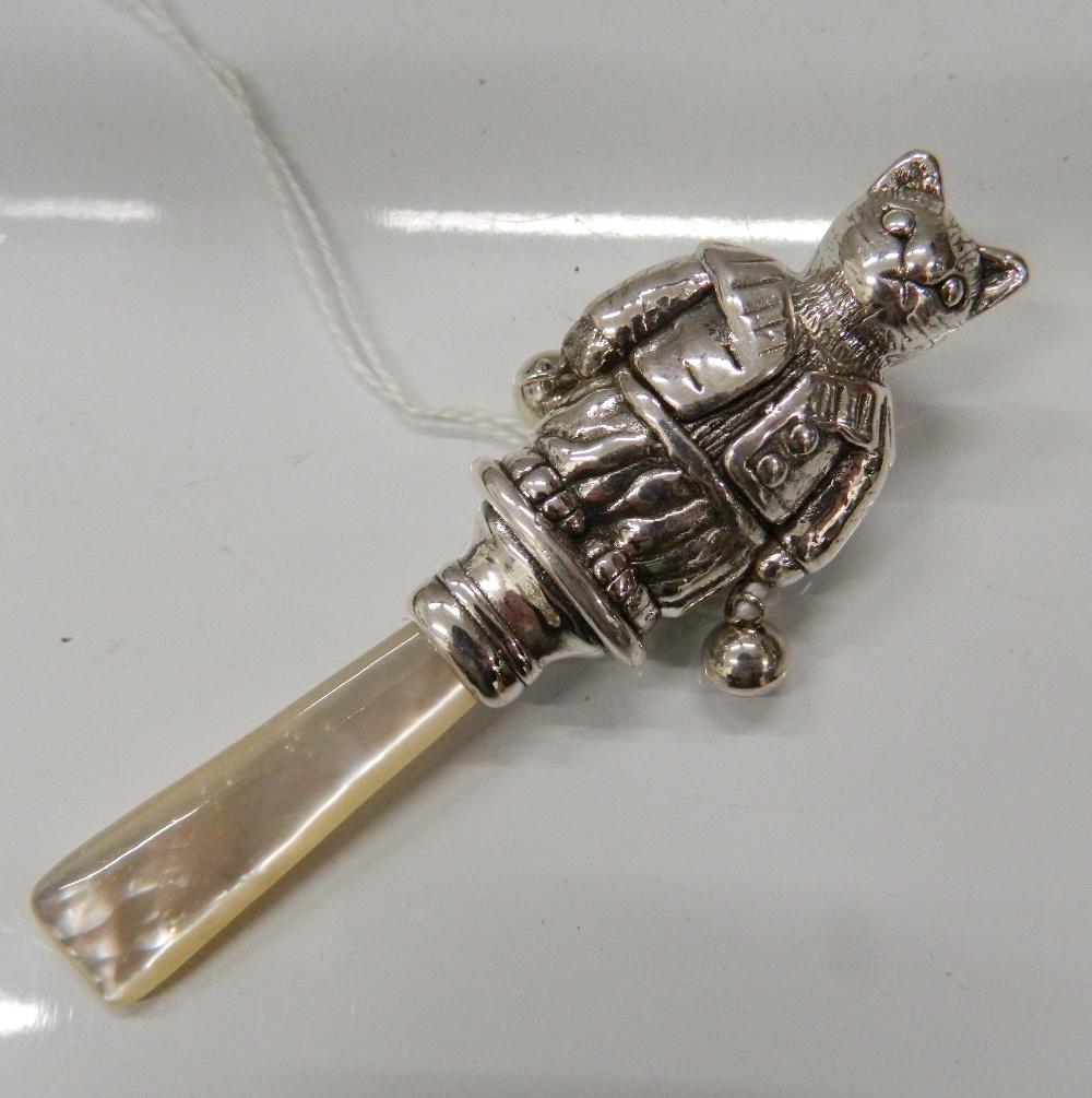 A silver rattle formed as a cat. 9 cm long.