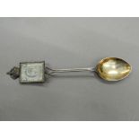 An Edward VII Coronation spoon inset with a stamp. 13 cm long (13 grammes total weight).