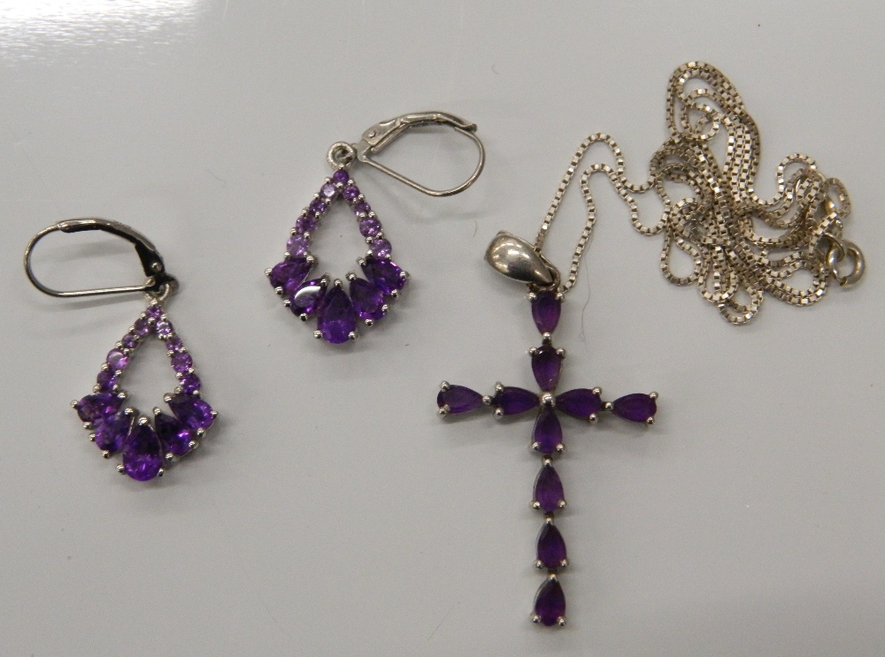 A pair of silver stone set earrings and a silver stone set cross on chain. The cross 3.5 cm high (9.