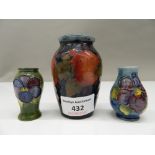 A small Moorcroft vase and two miniature Moorcroft vases. The former 8 cm high.