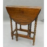 An early 20th century oak drop leaf table. 61 cm wide.