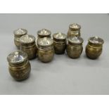 Nine miniature silver salts and peppers. Each approximately 3.5 cm high (99.