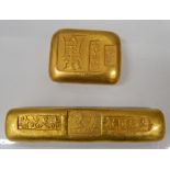 Two golden paperweights. 9.75 x 2 cm and 4.5 x 3.5 cm.