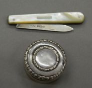 A silver pill box, together with a silver and mother-of-pearl penknife. Pill box 3.25 cm diameter.