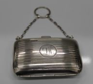 A silver purse with finger ring and chain, with fitted interior. 8 cm wide (67.