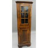 An early 20th century walnut corner cabinet of small proportions. 155.5 cm high.