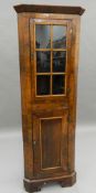 An early 20th century walnut corner cabinet of small proportions. 155.5 cm high.