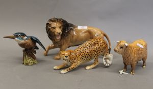 Four Beswick animals, a lion, a cheetah, a kingfisher and a highland cow. The lion 27 cm long.
