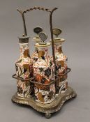 A four bottle silver plated cruet stand, the porcelain bottles decorated in the Imari palette.